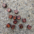 12 marbled red and gold dice on a textured rock