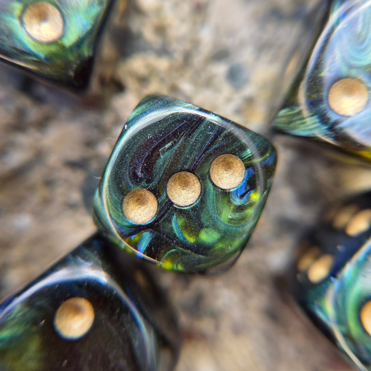 close-up of a green die with golden pips