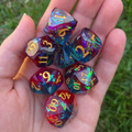 A full set of colorful polyhedral dice held in a hand