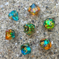A full set of colorful, blue and orange dice sitting on a concrete surface