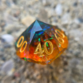 Bright orange and dark blue percentile die with gold numbers