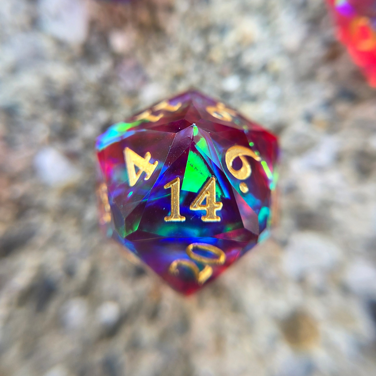 A close up of a red and blue d20 with a particularly reflective piece of bright greenish, holographic foil inside