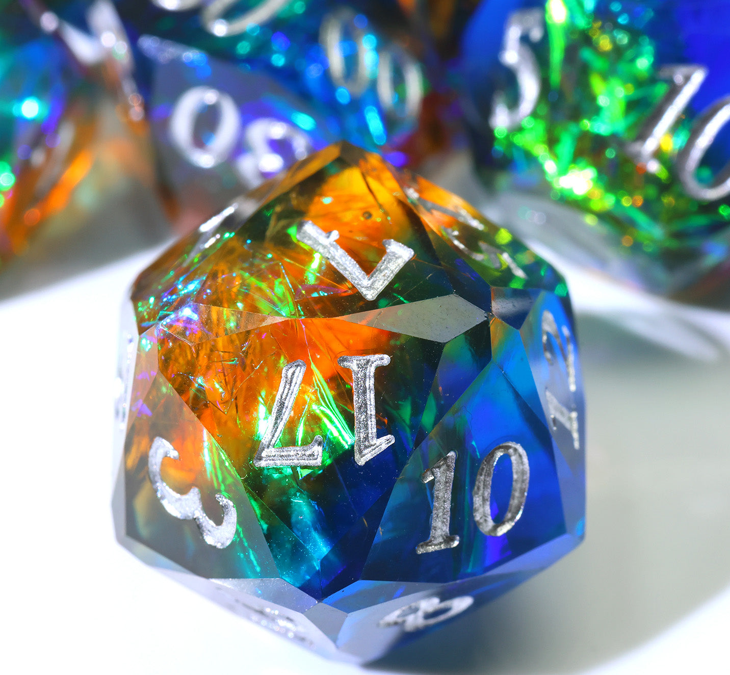 single blue and orange resin twenty-sided die with colorful paper and silver numbers
