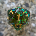 Multicolored green d20 with a blurred background