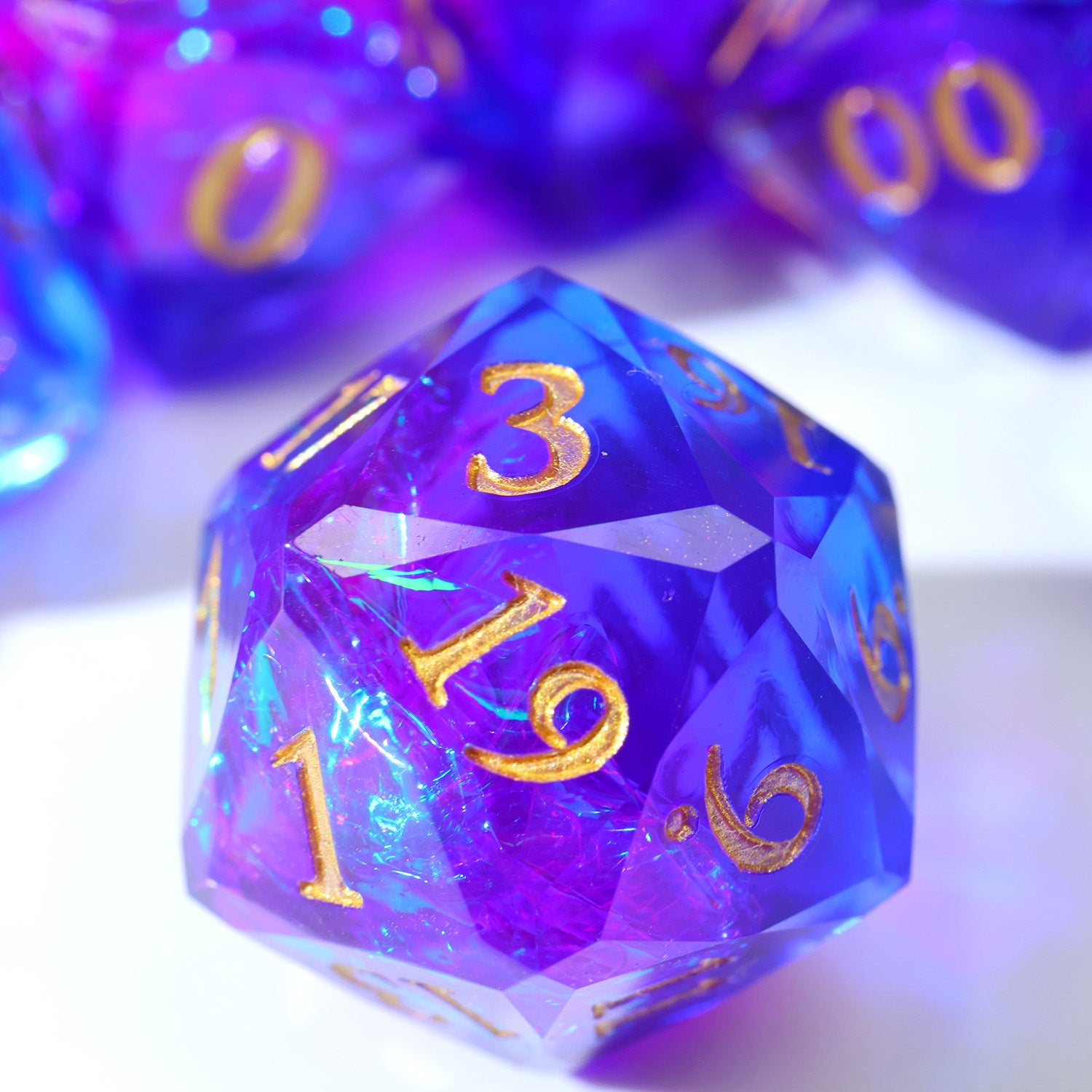 Multicolored polyhedral dice with gold numbers on a white background
