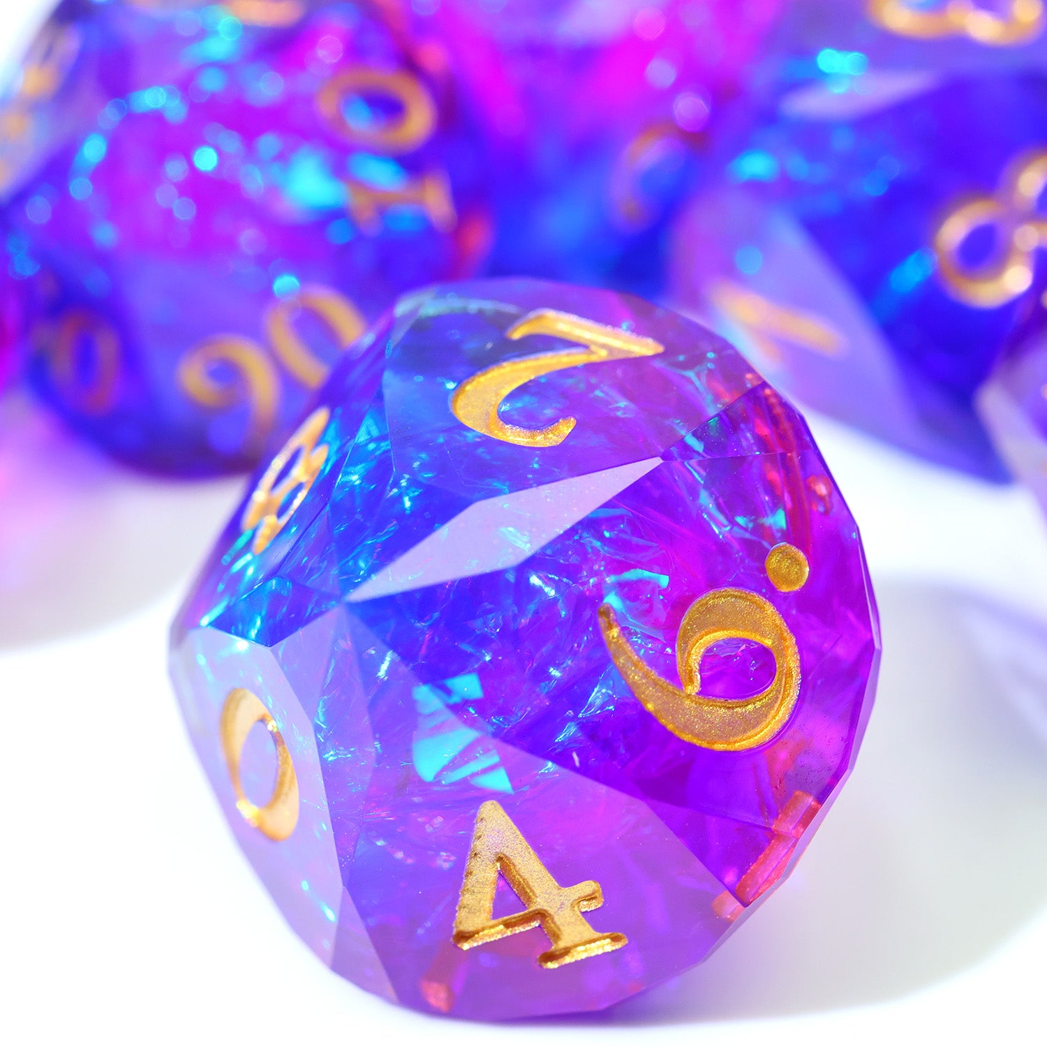 Set of purple and blue polyhedral dice with gold numbers on a white background